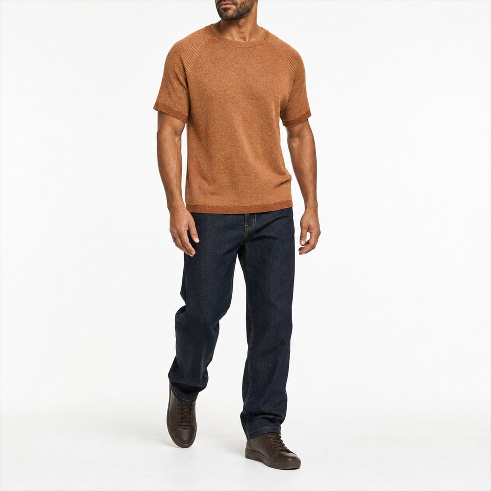 Man wearing the marled terracotta knitted tee with navy trousers, full view