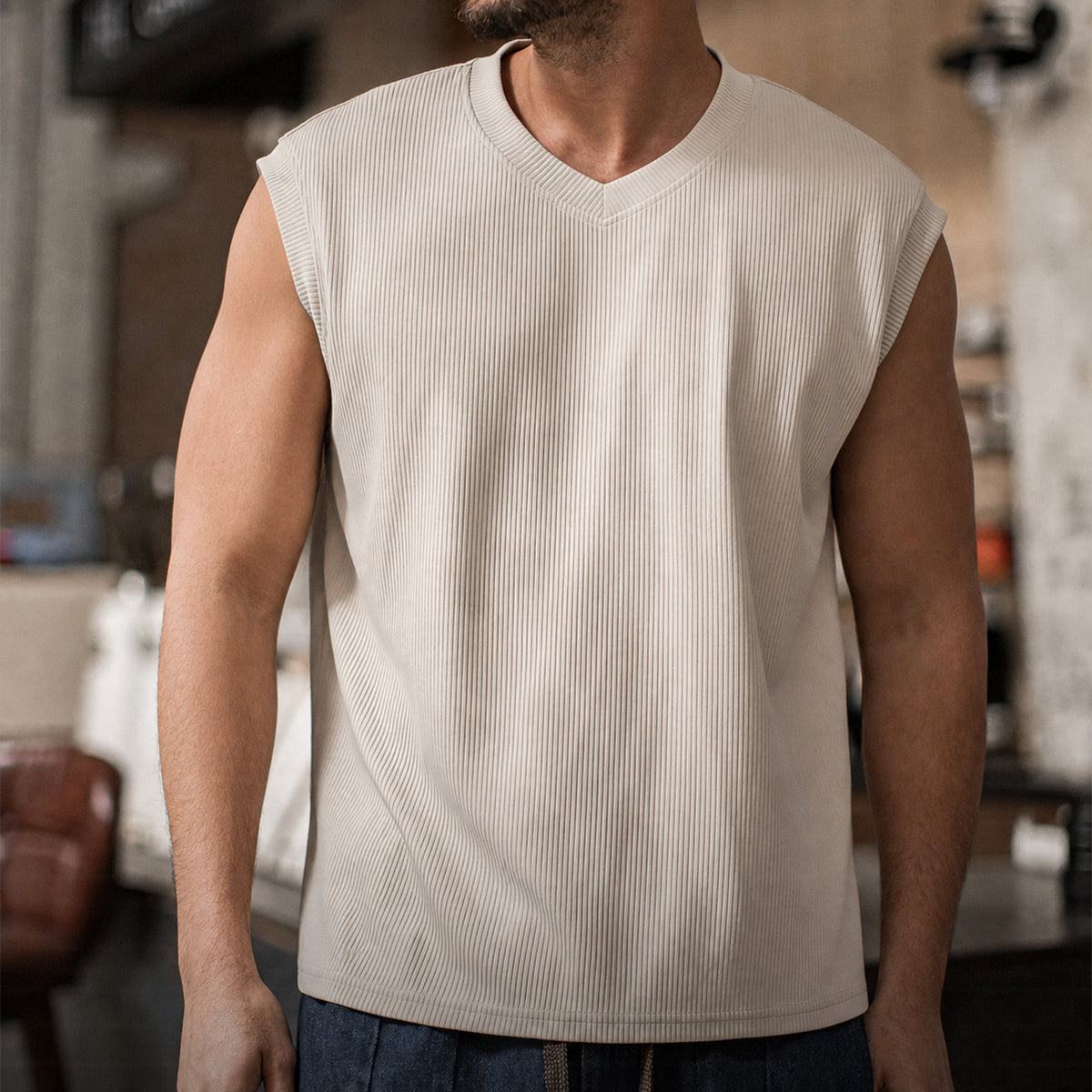Man in the khaki ribbed v-neck tank with blue jeans, front view
